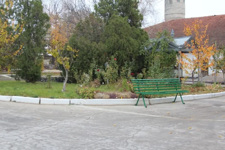 O bancă verde în grădina din curtea cramei