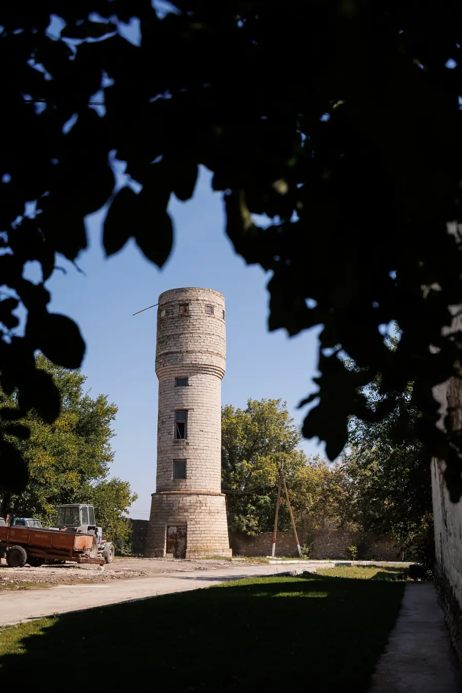 Turnul de apă din cărămidă al cramei, văzut printre frunze